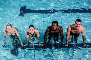 Fit smiling group pedaling on swimming bike